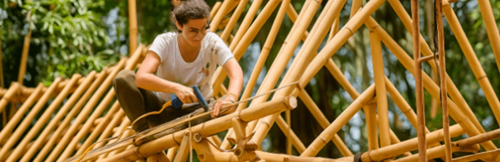 woman working on a bamboo roof